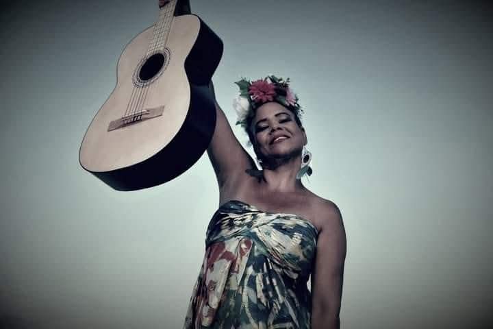 Neuz levanta su guitarra en una fotografía artística